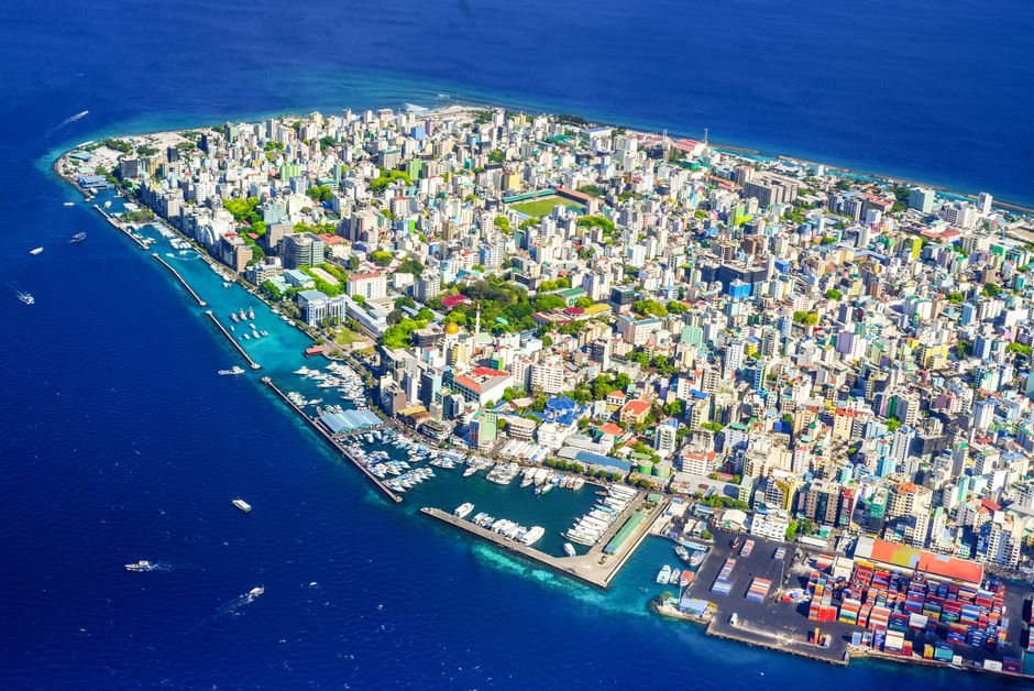 Vibrant aerial view of Malé City, Maldives, showcasing the bustling harbor and vivid cityscape.