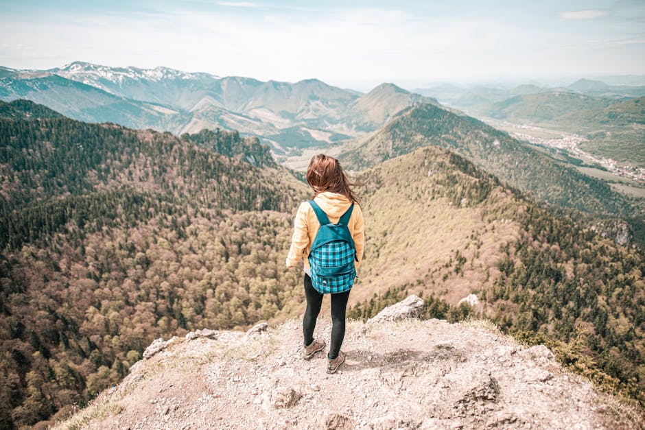 Woman overlooks Malá Fatra mountain range in Slovakia. Captivating scenic view from peak.