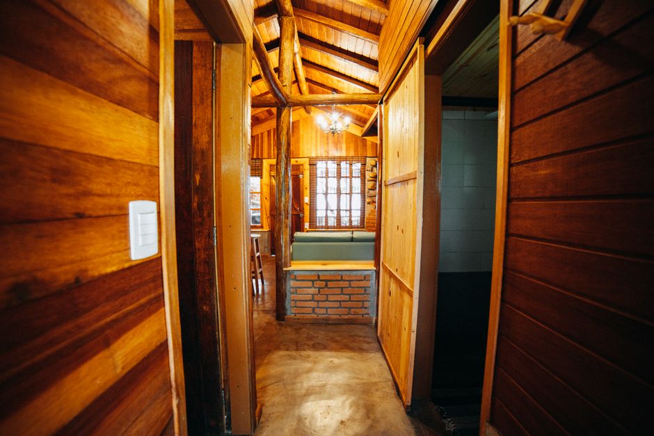 Explore the warm wooden interior of a cozy cabin featuring a hallway and seating area.