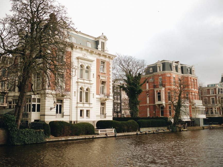 Charming 17th-century mansions line a picturesque canal in Amsterdam, showcasing classic Dutch architecture.