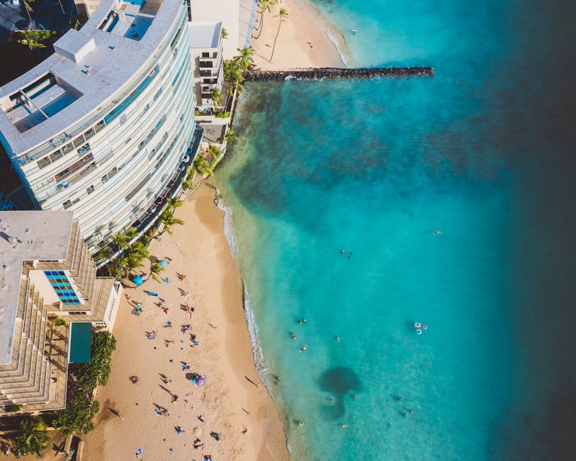 Stunning aerial view of a beach resort with clear turquoise waters, attracting tourists for a perfect holiday.