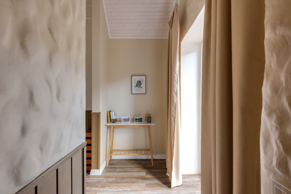 Stylish hallway with minimalist decor, wood floor, and soft lighting.