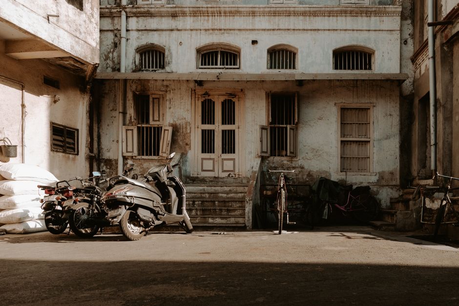 Urban scene showing an abandoned building and motorcycles in Ahmedabad, India.