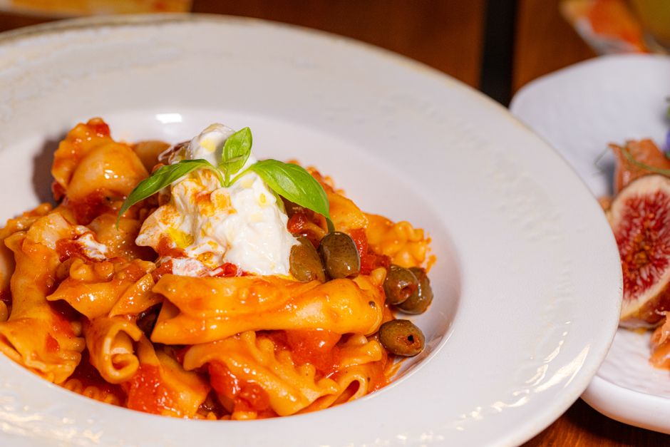 Tasty pasta with olives and cheese garnish, ideal for culinary themes.