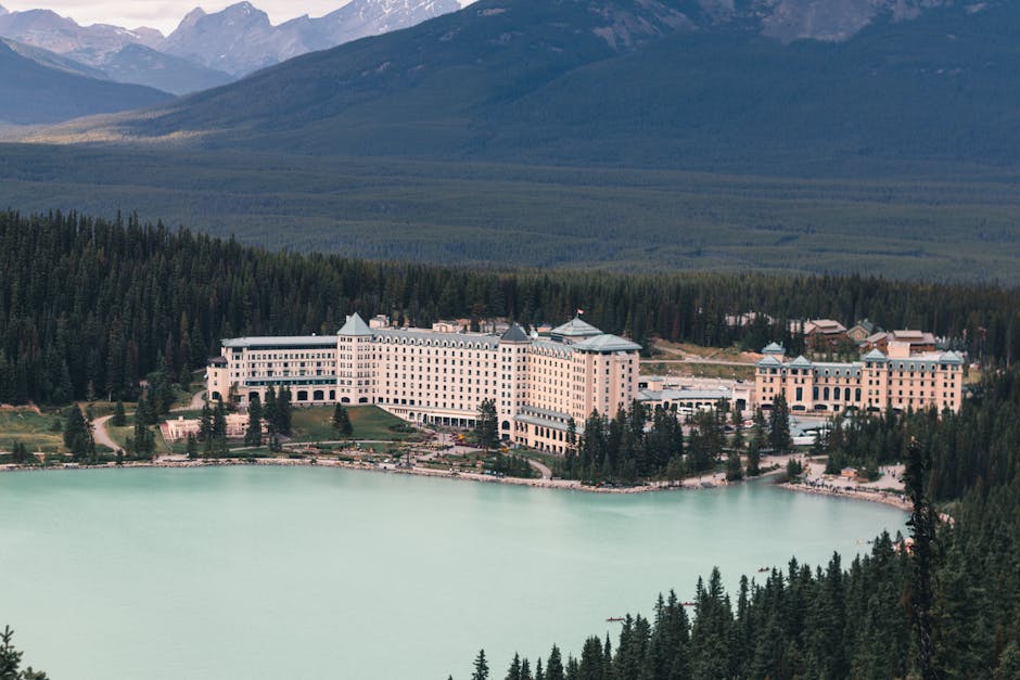 Aerial view of the Fairmont Chateau in stunning Lake Louise, surrounded by forest and mountains.