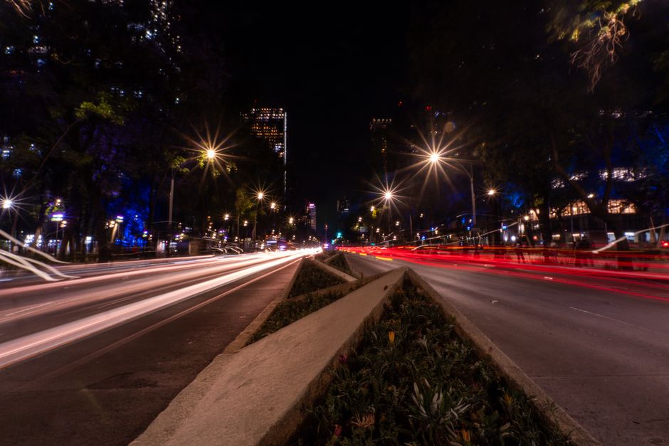 Long exposure of busy night traffic on a major boulevard in Mexico City, highlighting vibrant lights.