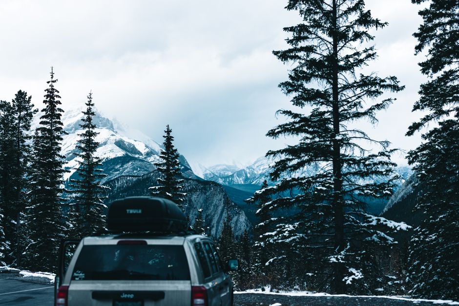 Explore the serene winter landscape of Banff National Park with snow-capped mountains and evergreen trees.