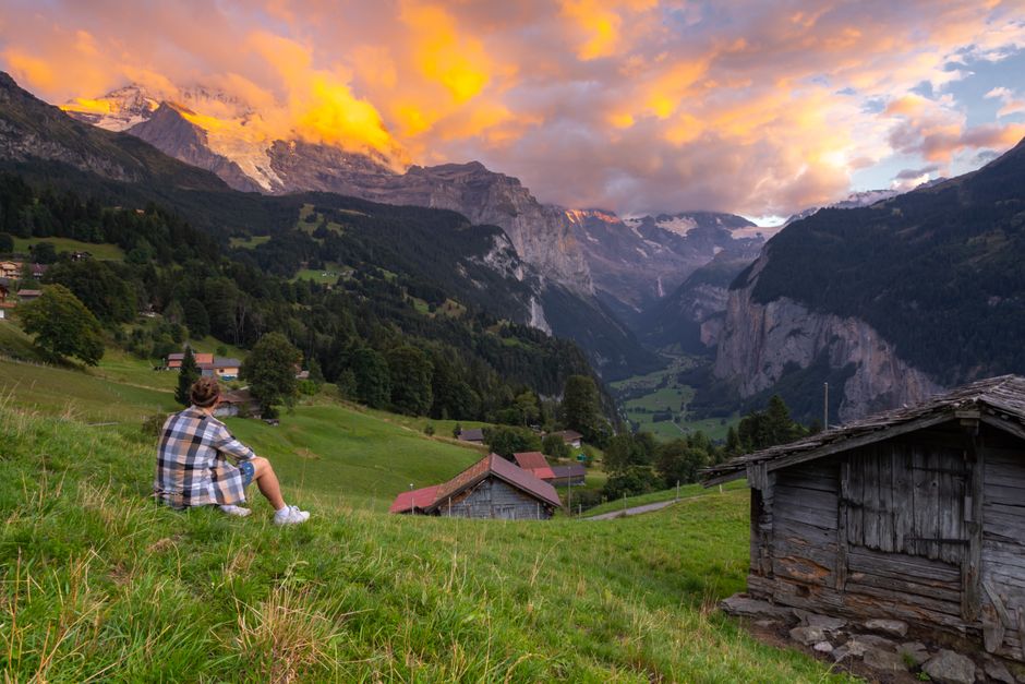 A serene sunset view of Lauterbrunnen Valley in Switzerland with vibrant skies and majestic mountains.