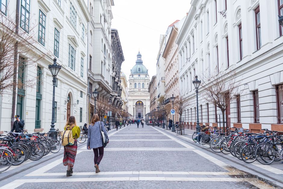 Pedestrian street leading to St. Stephen's Basilica in Budapest, featuring urban architecture.