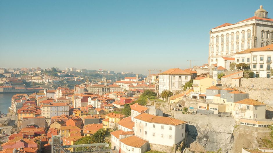 Aerial view of Porto, Portugal showcasing historic architecture and vibrant rooftops under a clear sky.