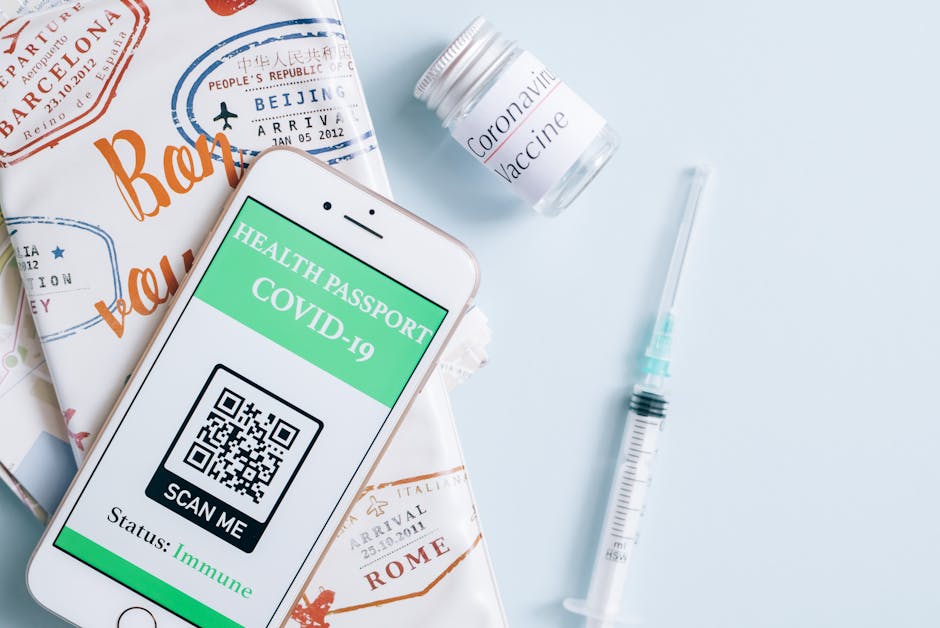 Image of a smartphone displaying a COVID-19 health passport next to a vaccine vial and syringe, ready for travel.
