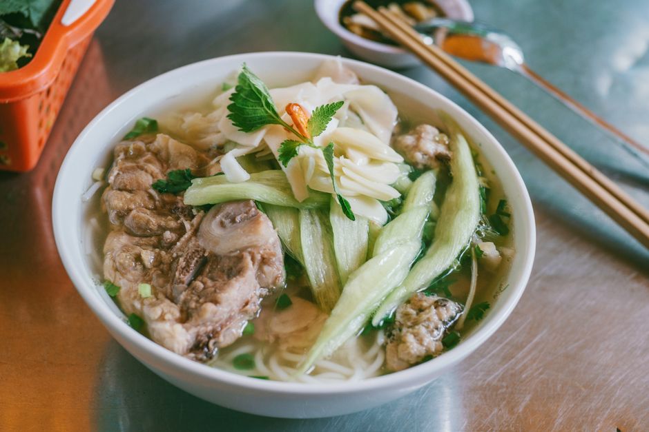 Delicious bowl of Vietnamese pho with pork and fresh vegetables, ready to enjoy.