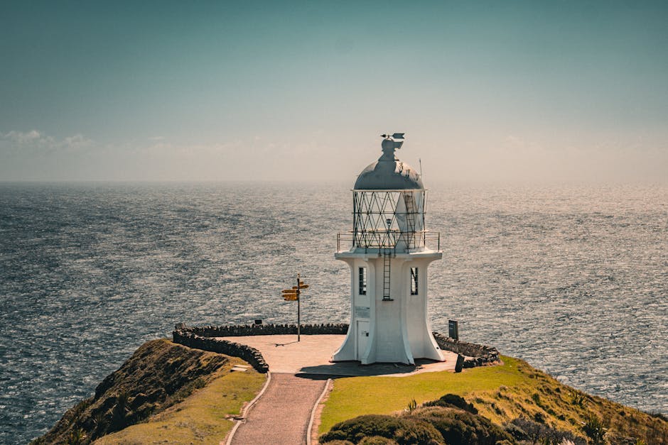 View of Cape Reinga Lighthouse with dramatic ocean backdrop, Northland, New Zealand.
