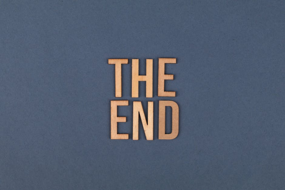 Wooden letters form 'The End' on a plain blue surface, ideal for concluding or finality themes.
